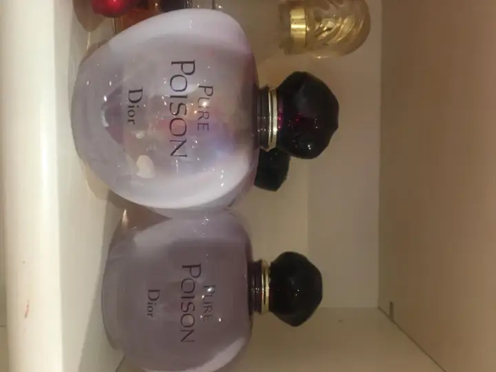 Dwa flakony perfum Pure Poison Dior 100ml, każdy z fioletową poświatą i czarnym korkiem.